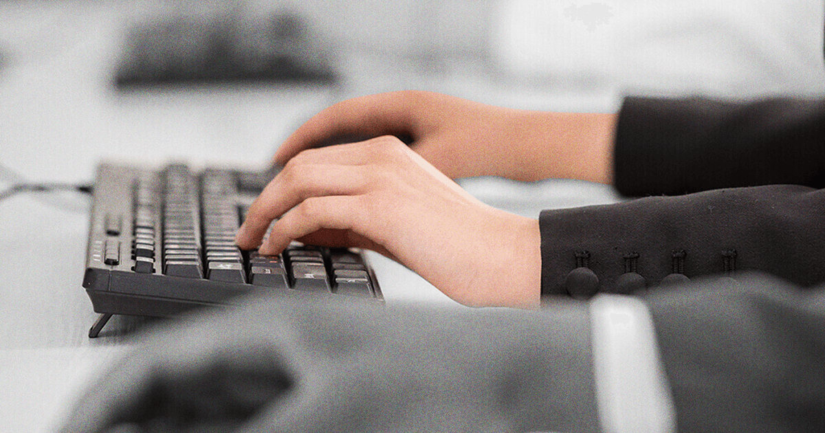 Person typing on keyboard in professional attire